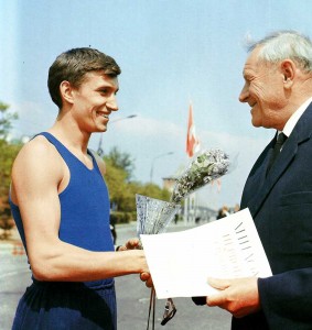 Honoured master of sports, presents his prize to a relay race winner