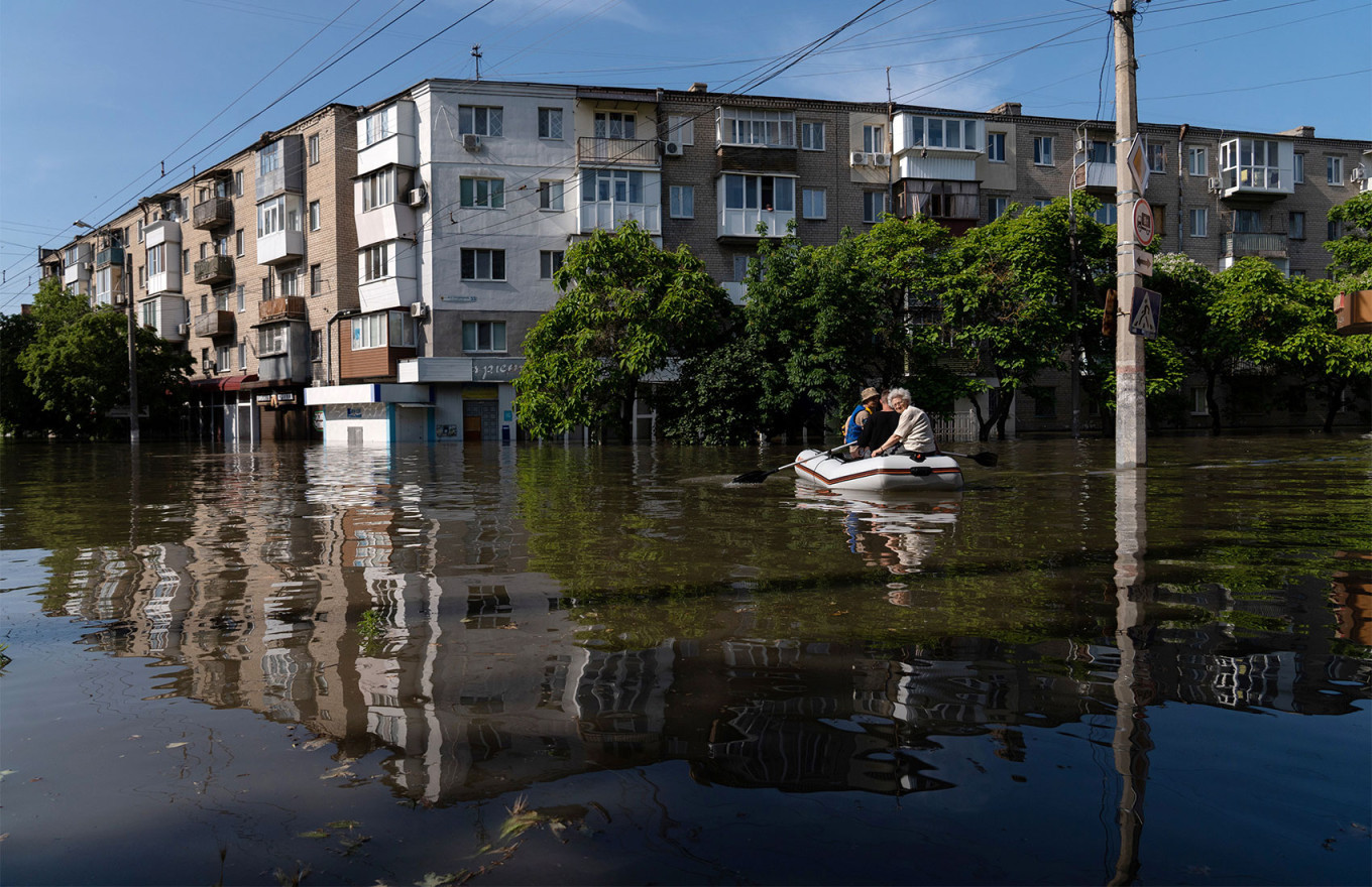  Ukrainian security forces transport local residents in a boat during an evacuation from a flooded area in Kherson. Aleksei Filippov / AFP 