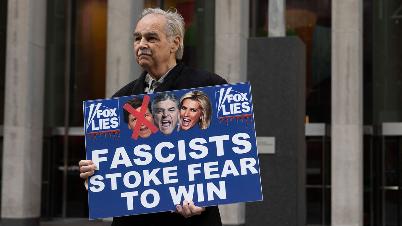  A protester outside of Fox News Headquarters holds a sign with images of Fox anchors Tucker Carlson. Gina M Randazzo / ZUMA Press Wire / TASS 