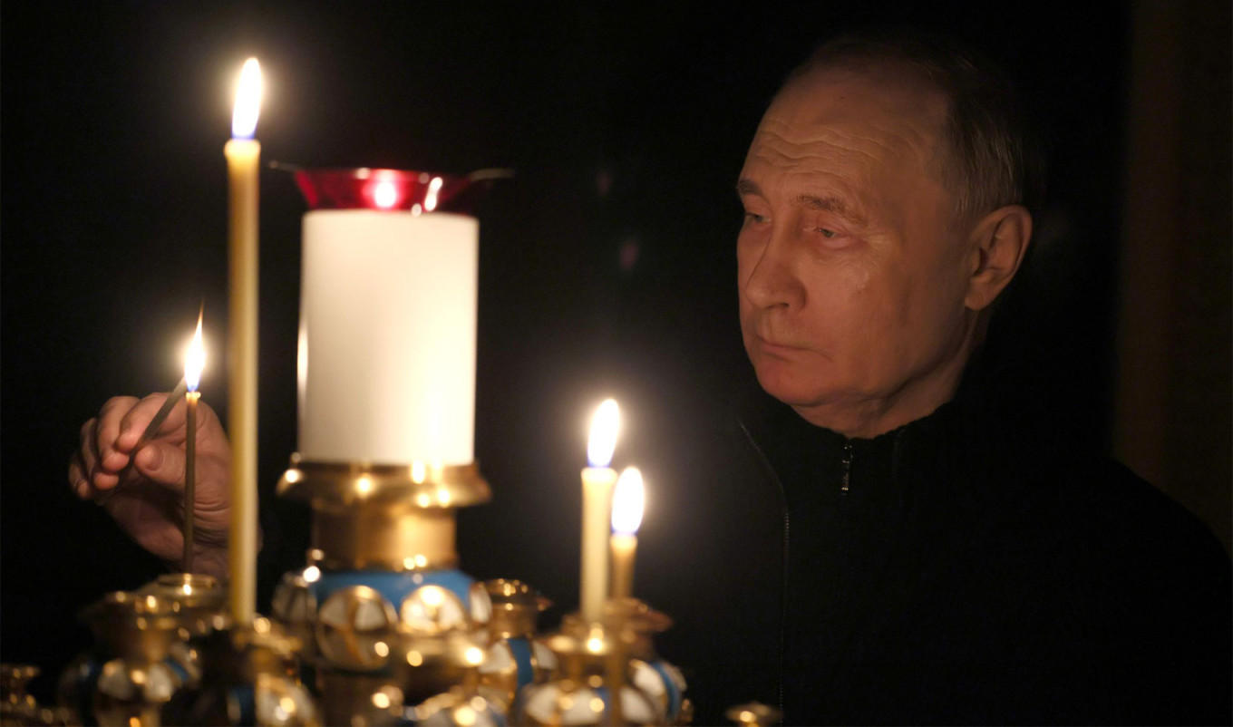  Vladimir Putin places a candle in memory of those killed in the terrorist attack in the church of the Novo-Ogaryovo residence on March 24. kremlin.ru 