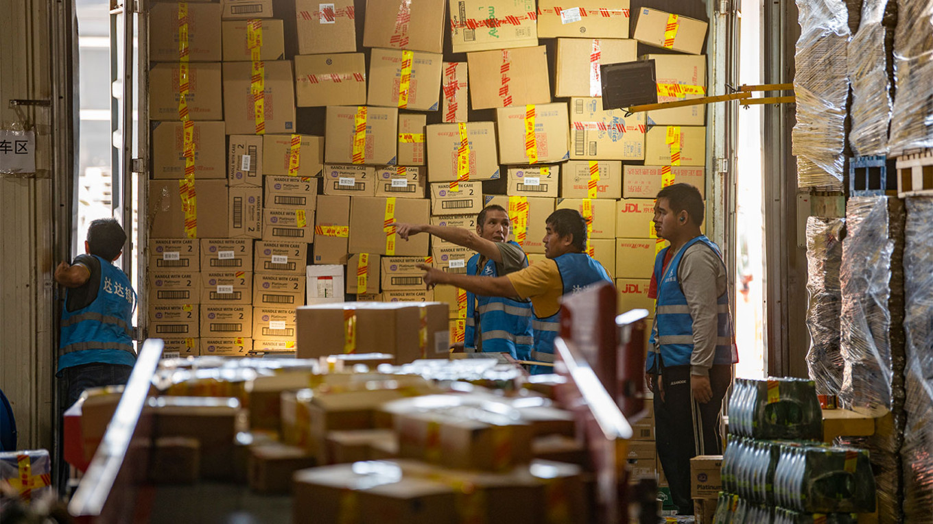  Workers pack goods into boxes at the warehouse of a Chinese e-commerce company. Hu Xiaofei / VCG / TASS 