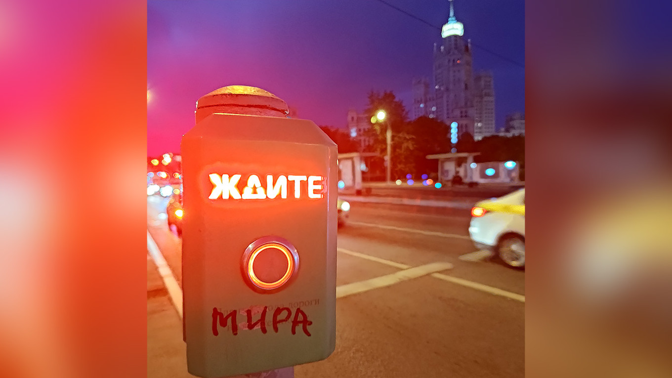  A pedestrian crossing button at a traffic light in Moscow with the word "Wait," where someone has added "Mira" ["for peace"], making it read "Wait for peace." MT 