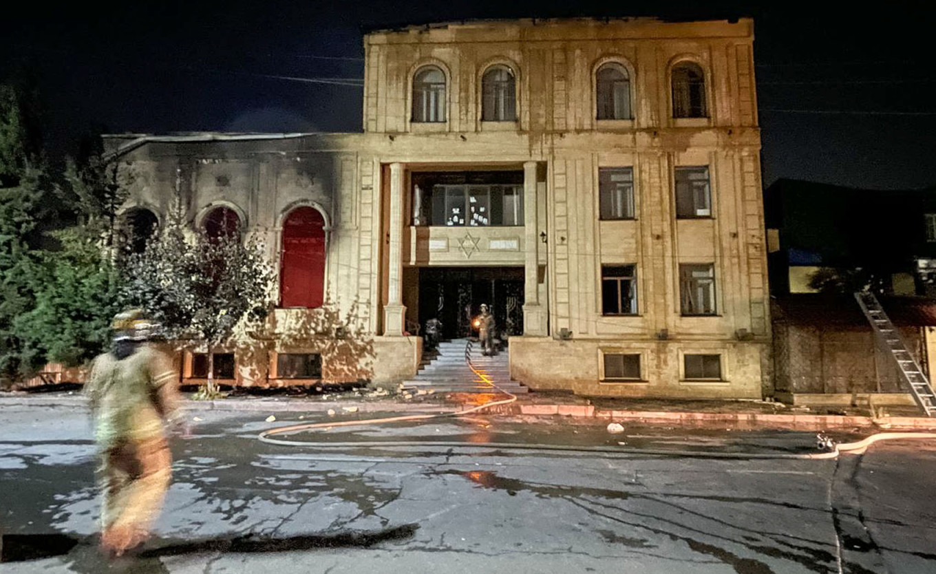  Emergency workers approach a fire-hit local synagogue in Derbent. Gyanzhevi Gadzhibalayev / TASS 