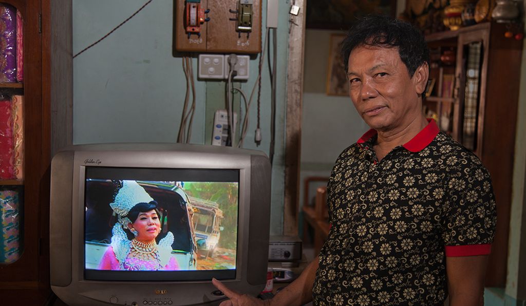 Mor Me Noe, a famous nat kadaw in Mandalay, showing the video of their performance at a spirit festival